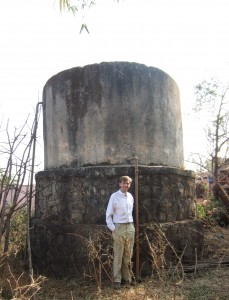 Adam standing next to a water storage tank in rural Maharashtra, India.